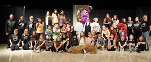 Drama performers and crew posing on stage for Peter Pan